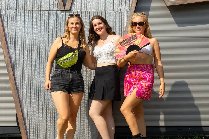 Typische Festivalbesucher in bunten Farben und mit Sonnenbrillen. Fröhliche Stimmung und ein Gefühl von Freiheit.
